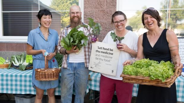 Zenger Farm farm share team poses at the Southeast Portland pick-up site. From left, 博彩网站 Jennifer Tsai, farmer Scott Suzadail, and county staffers Carla Remeschatis and Katy Pranian.