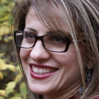 Headshot photo of a woman wearing eye glasses who is smiling