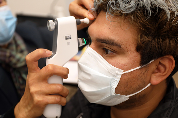 Man with machine close to his eye for vision screening.