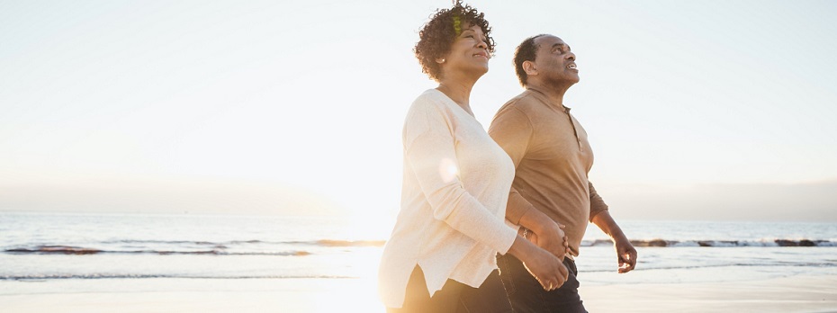 Photo of people smiling walking on a beach