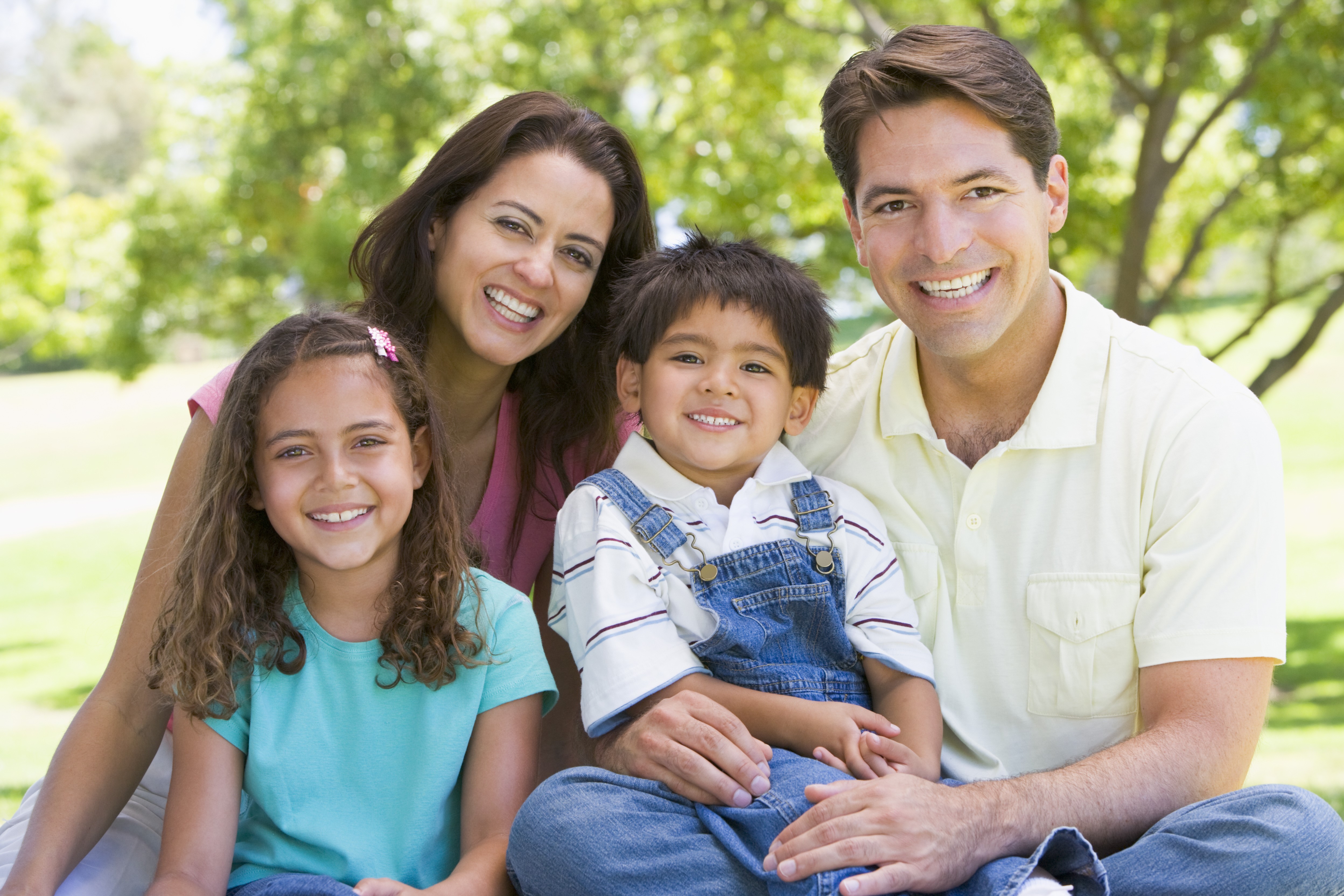 Mother Daughter Son and Father sitting outside together. Diverse family