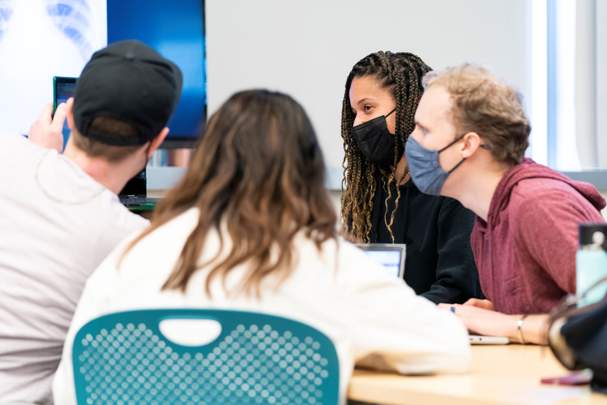 Students sitting around the table and discussing.