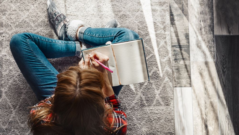 Teenager writing in a journal