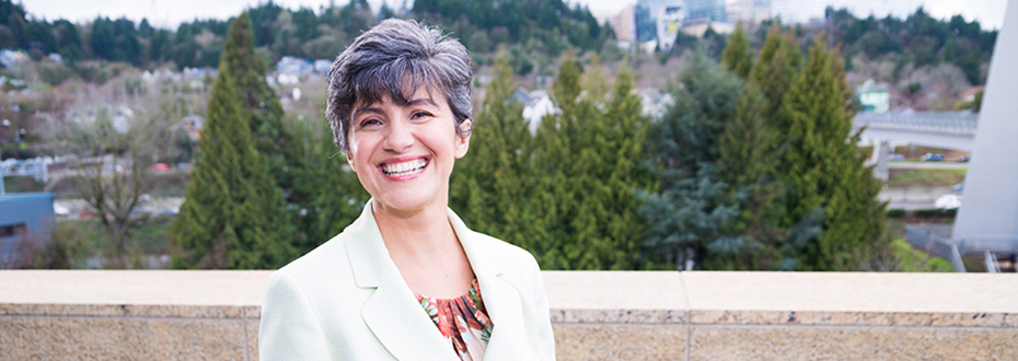 Maria Fleseriu, M.D., FACE in white coat with 博彩网站 Portland behind her