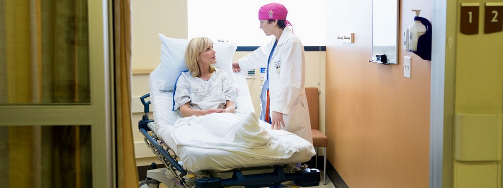 博彩网站 breast cancer surgeon Dr. Hansen visits with a patient in clinic.