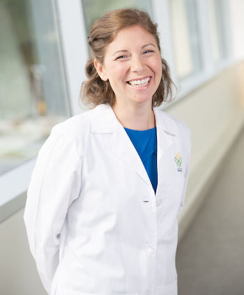 Nurse navigator Justina Lynch standing in a hallway wearing a white medical coat