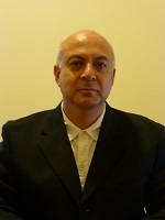 Headshot of Dr. Arie Baratt wearing a black blazer and white shirt. 