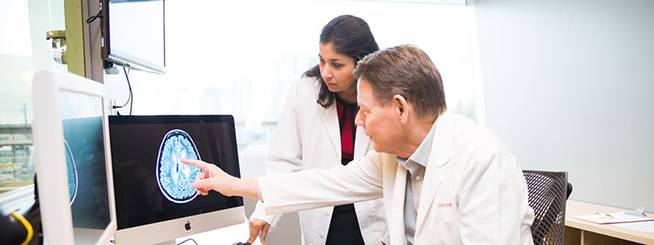 Dr. Vijayshree Yadav and Dr. Dennis Bourdette analyzing a brain scan