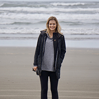 A woman smiling at the beach.