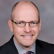 smiling man in glasses and a suit