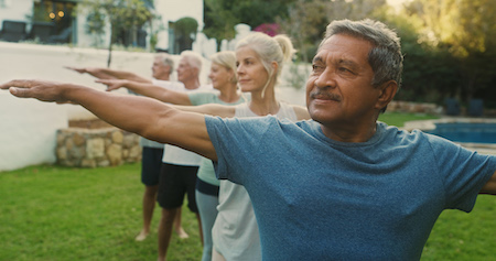A group of people doing yoga outside.