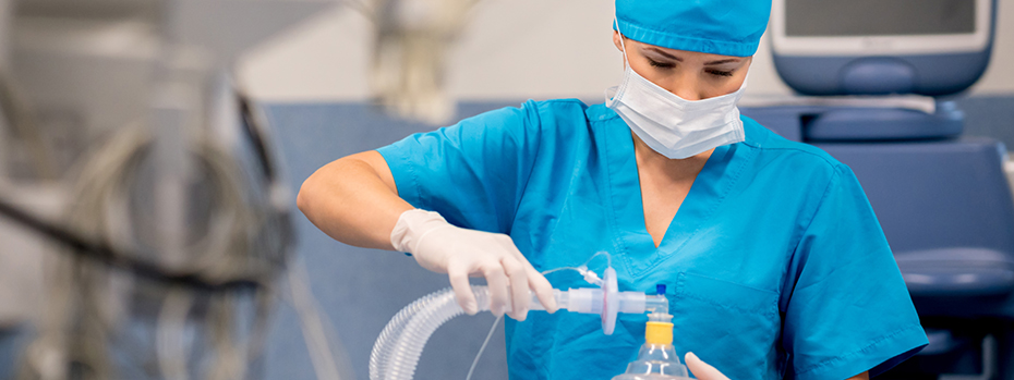 A respiratory therapist adjusts her patient’s oxygen mask.