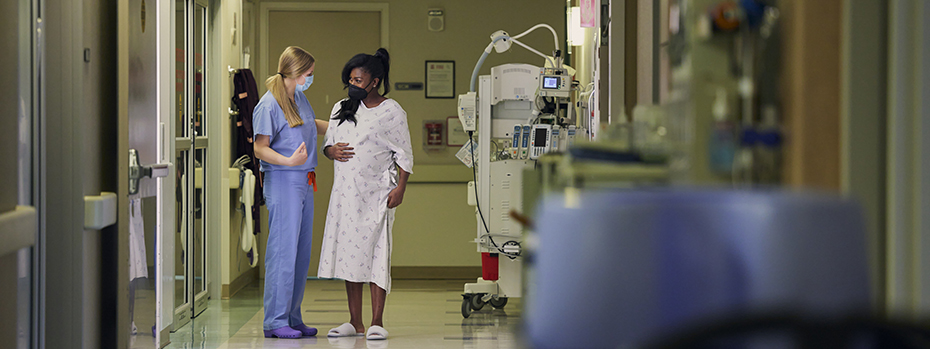 Nurse-midwife Bridget Lee and her patient in labor walk through the hallway of 博彩网站’s Family Birthing Center.