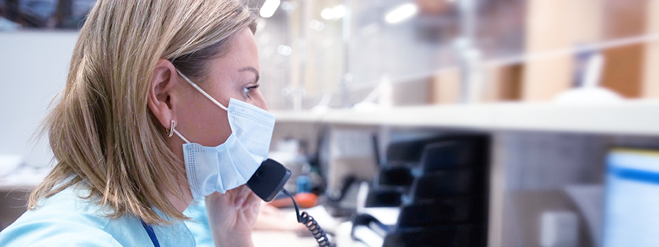 A health care worker talks on the phone. We are ready to help our acute care partners 24/7.