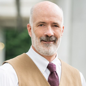 smiling man with beard, in vest and tie
