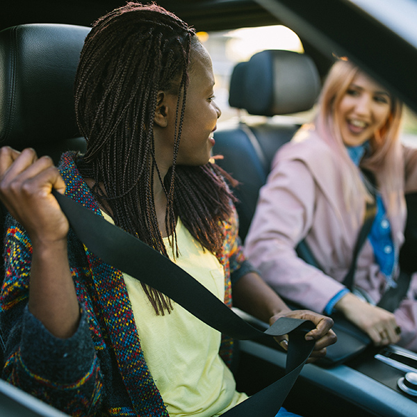 Two smiling people share a car ride