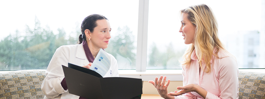 A patient is conferring with a doctor. They are sitting on a couch in a room filled with light. The mood is warm and optimistic.