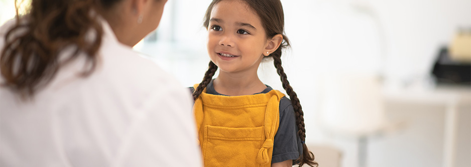 A smiling child and healthcare provider.