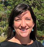 A photo Kathleen Young smiling outside on a sunny day.