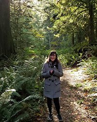 A woman standing in a forest.