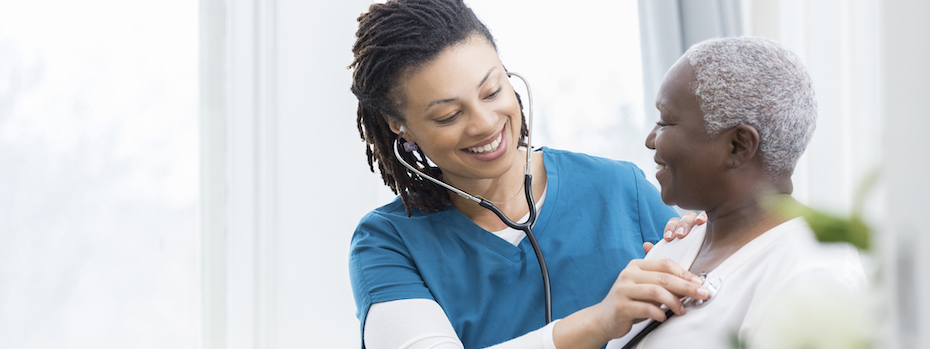 A healthcare provider listens to a patient's heart with a stethoscope.