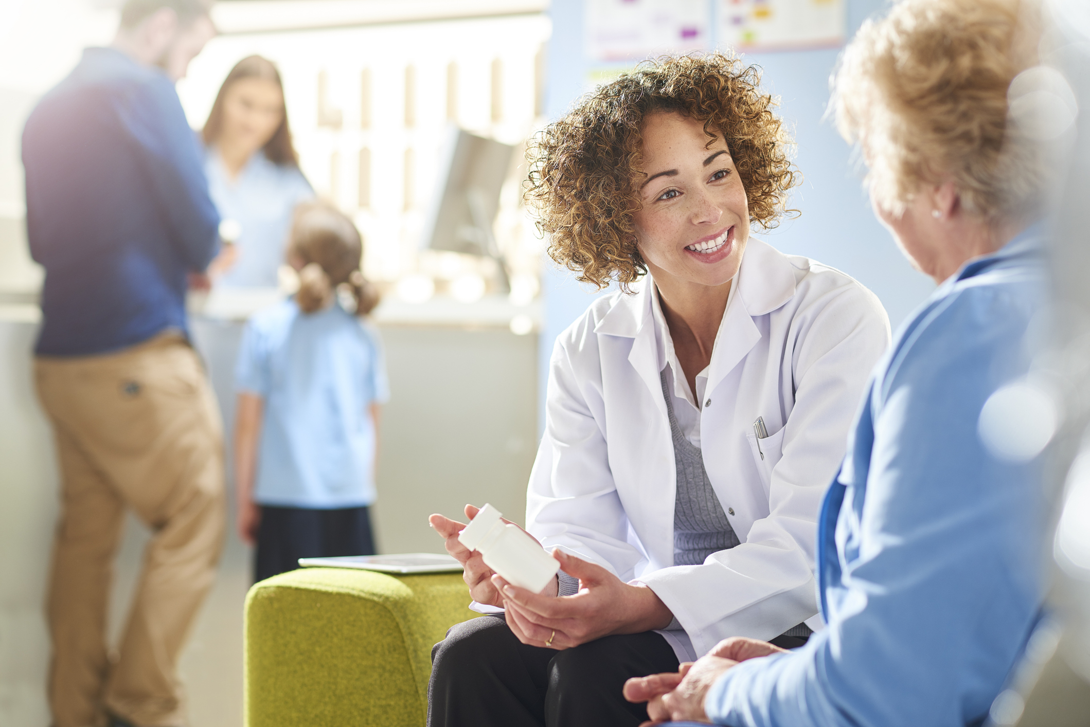 A female pharmacist explains how to properly take a medication to an elderly female patient.