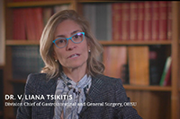 A woman speaking into a camera in front of a bookshelf with text superimposed over the image that reads "Dr. V. Liana Tsikitis, Division Chief of Gastrointestinal and General Surgery, 博彩网站."