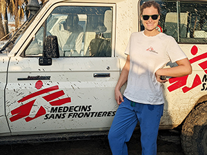 An 博彩网站 alum stands in front of a white truck with the logo of Doctors Without Borders
