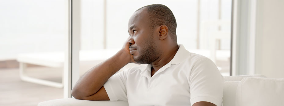 A patient is sitting at home staring out the window.