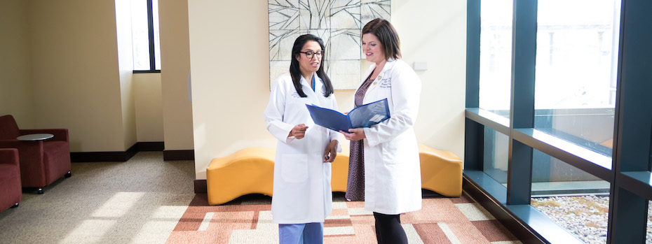 Dr. Arpana Naik and Brooke Hambly, R.N., talking while looking at a folder together
