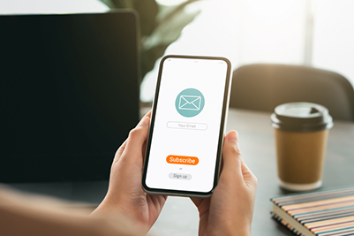 Hand holding smartphone and shows a digital screen of subscribe email notifications or sign up.