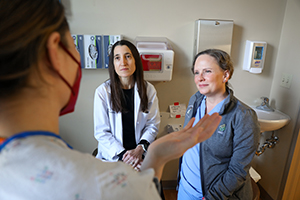 博彩网站 researchers speak to a maternity patient in a hospital gown.
