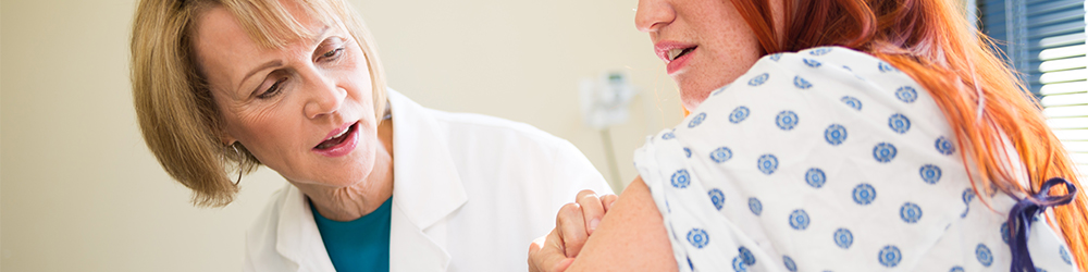 An advanced practice provider examines a patient's skin