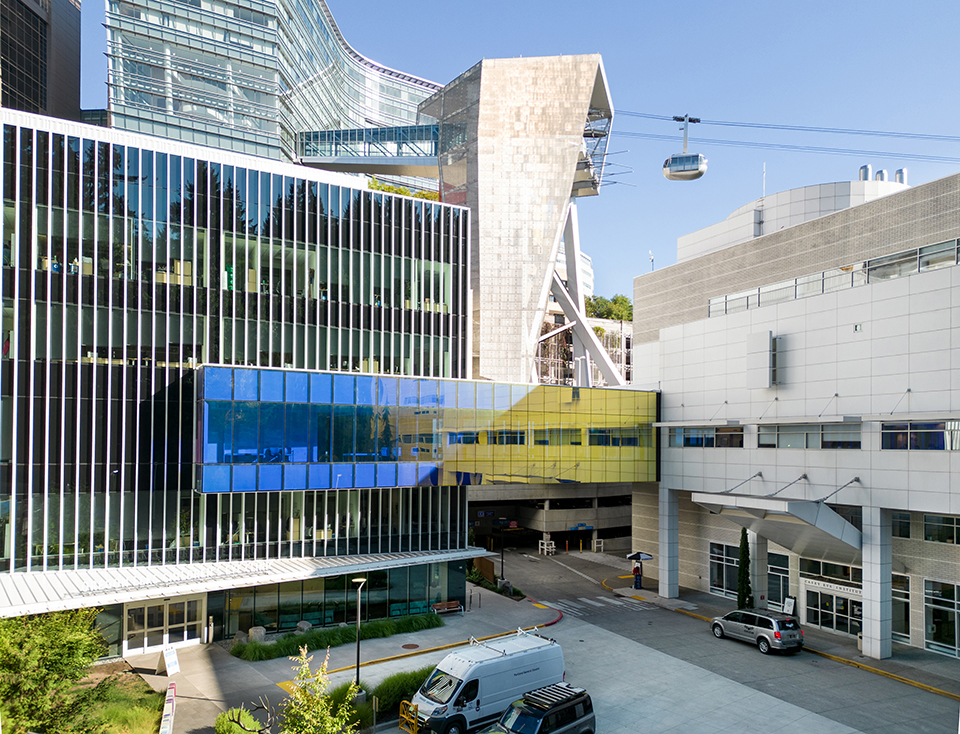A photo of the Casey Eye Institute and Elks Children's Eye Clinic buildings with the tram in the background.
