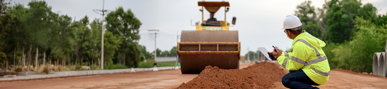 Inspection of each layer of laterite soil landfilling near vibratory roller compactor machine.