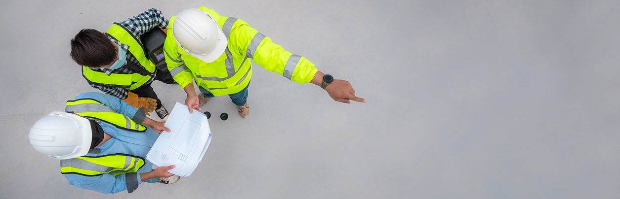 Civil engineer inspect structure at construction site against blueprint.