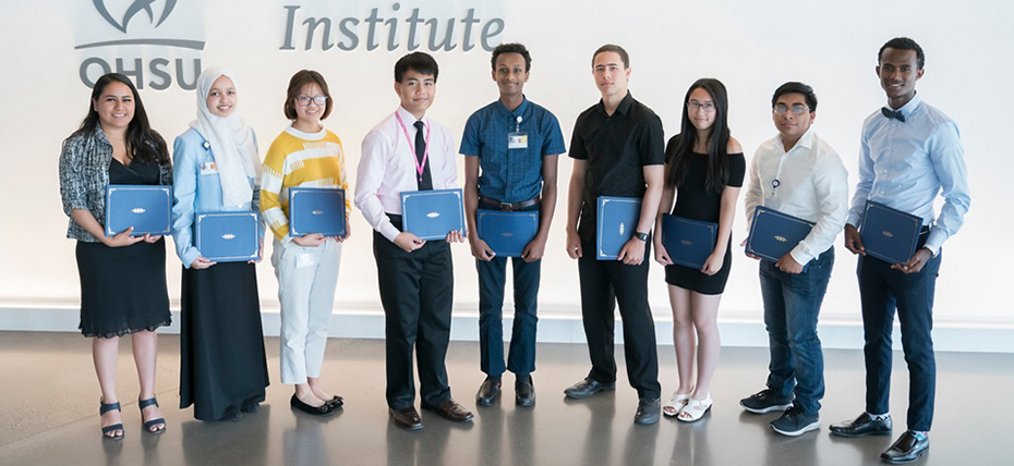 Nine people standing in a row, each holding a certificate in front of a wall with the 博彩网站 logo on it.