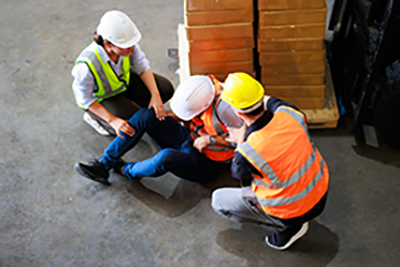 Injured worker receiving assistance from coworkers.