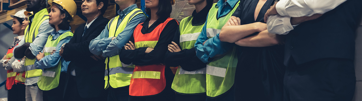Large group of factory worker standing together in warehouse or storehouse.