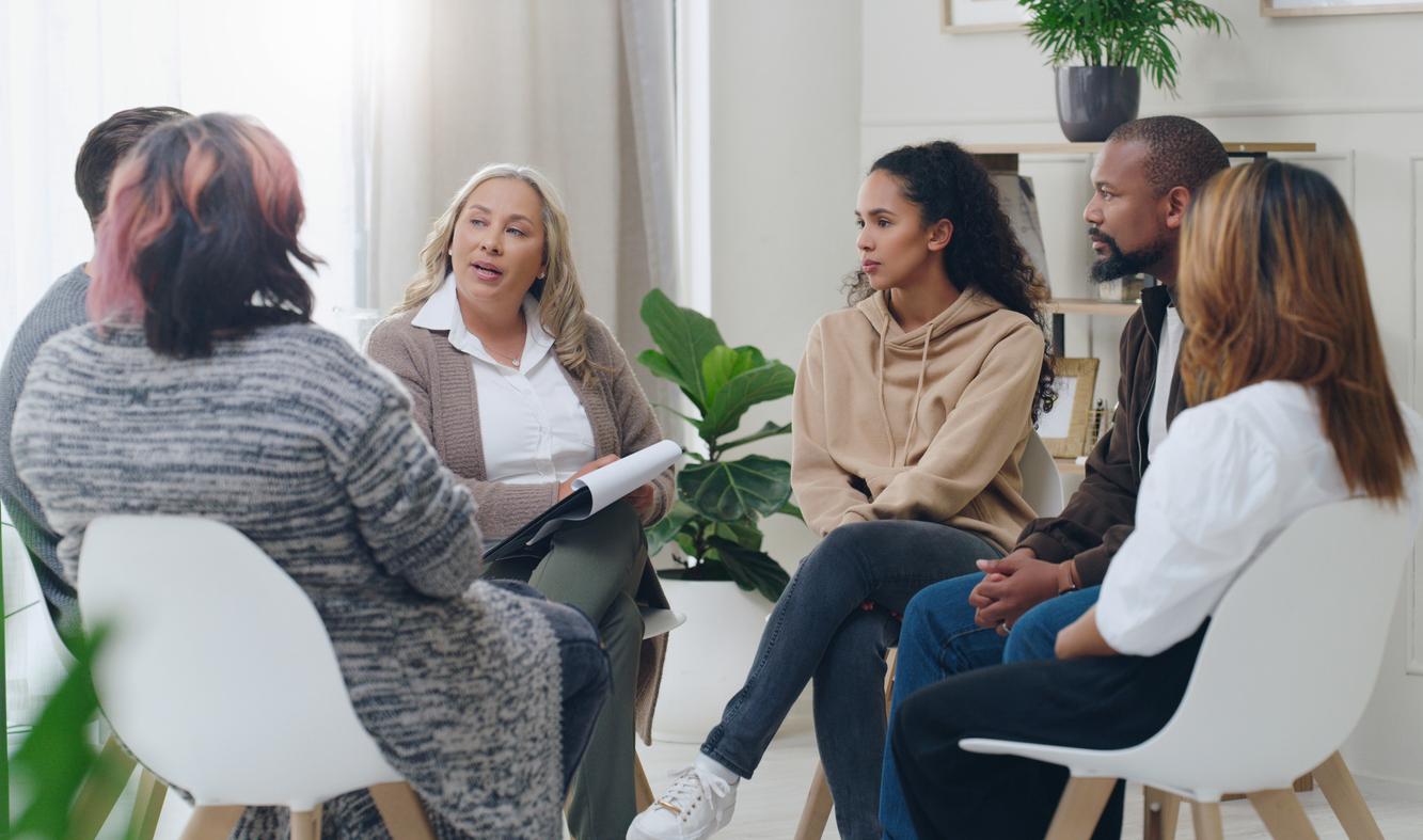 People gathered around a table talking during a meeting.