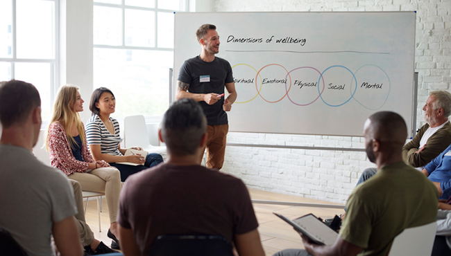 People in a room listening to a man give a presentation.