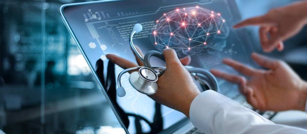 Three hands pointing at brain imaging data on a laptop screen. One hand is holding a stethoscope.