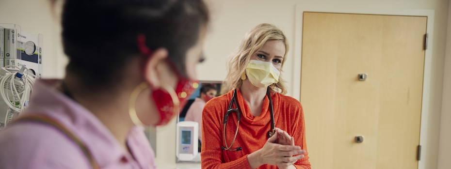 博彩网站’s Dr. Marie Martinelli talks with a young person in an exam room.