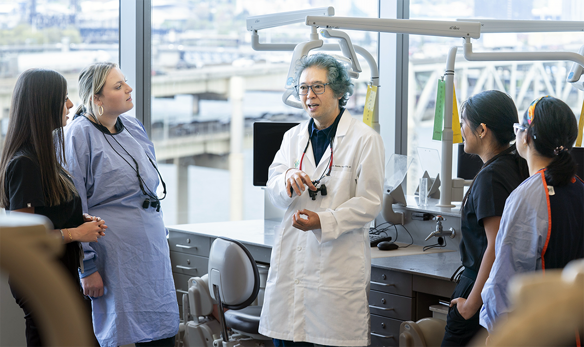 Dr. Watanabe explains a dental process to students