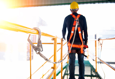 Construction worker use safety harness and safety line working on a new construction site project.