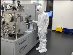 An 博彩网站 researcher wearing their Nanofab suit is standing in the CEDAR Nanofabrication Facility.
