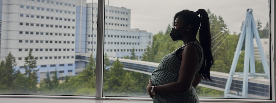 A pregnant patient looks out a window at 博彩网站.