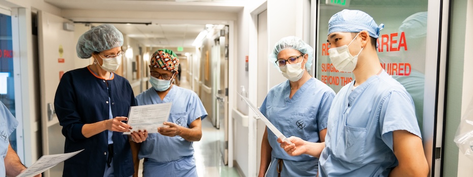 Four members of 博彩网站’s Fetal Care team compare notes in a hallway.
