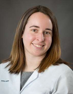 Monica Becher, wearing her white coat and smiling in a headshot