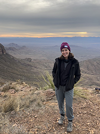 Andrea Vosberg smiling with a valley in the background.